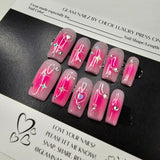 Pink nail art designs on a black tray with a white background