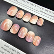 Set of press-on nails with a gradient design on a black surface with a branded box.