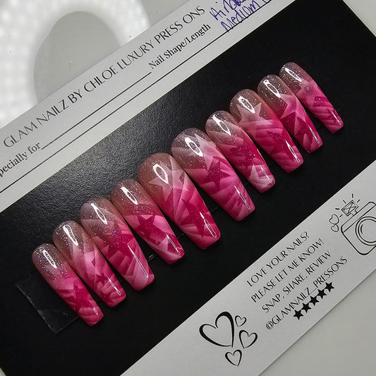 Pink and clear nail extensions on a black and white packaging with a ring light in the foreground.